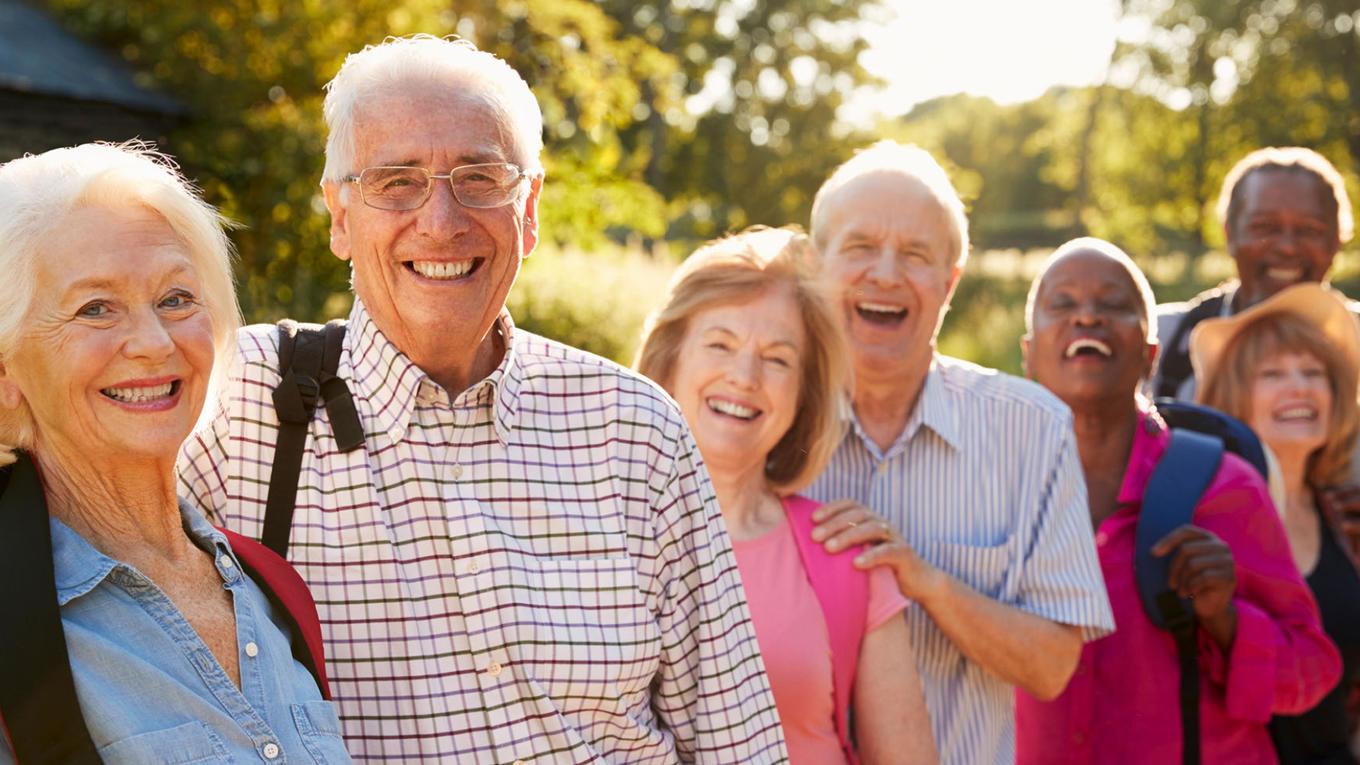 Group of seniors smiling outside in sunshine
