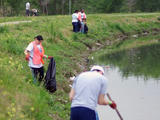 People cleaning up trash around a bayou